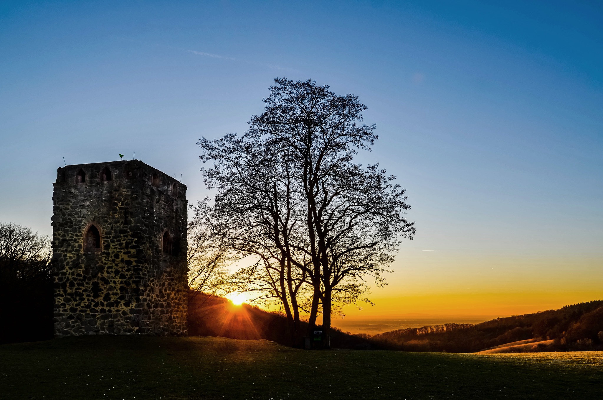Foto vom Sonnenuntergang hinter einem historischen Turm